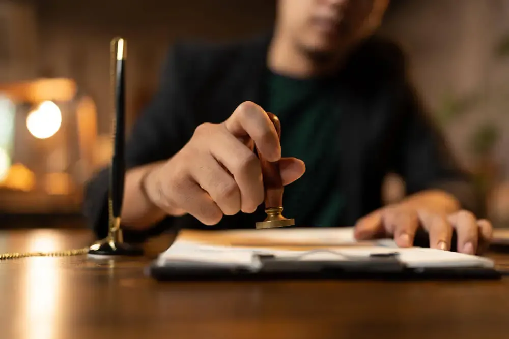 Vakreviewer in ons kantoor zet de stempel onder een afgeronde beëdigde vertaling