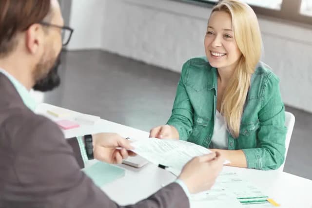 Klant overhandigt een document aan onze adviseur