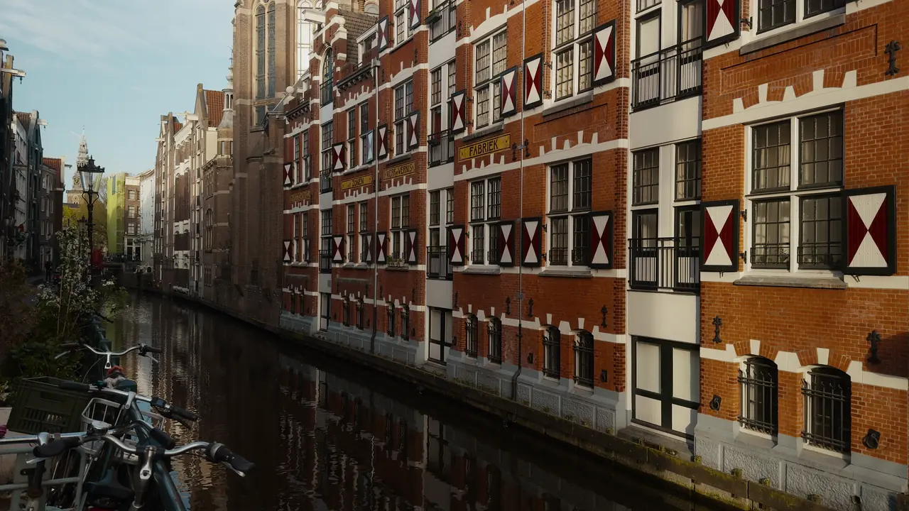 Grachtenpanden met rood-witte luiken langs een rustige Amsterdamse gracht (Kadaster en vastgoed)
